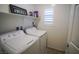 Bright laundry room with washer, dryer, and storage shelves at 161 Petaluma Valley Dr, Las Vegas, NV 89138