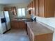 Traditional kitchen with oak cabinets, neutral countertops, tile flooring, and a stainless steel refrigerator at 2257 Colebrook St, Las Vegas, NV 89115