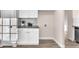 Bright laundry room with white cabinets, granite countertop, stylish backsplash and wood-look flooring at 4536 Rolls Royce Rd, North Las Vegas, NV 89031