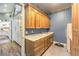 Laundry room with light wood cabinets, a utility sink, and a white tile floor at 5116 N Valadez St, Las Vegas, NV 89149