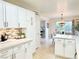 Open concept kitchen with white cabinets, an island, and views to dining area at 7733 Allerton Ave, Las Vegas, NV 89128