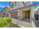 Two-story home with green door, attached garage, and stone accents at 7745 Rosebark Cliffs St, North Las Vegas, NV 89084