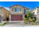 Two-story house with a red door and attached garage.Landscaped front yard at 7745 Rosebark Cliffs St, North Las Vegas, NV 89084