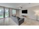 Living room with gray couch and large TV, access to backyard at 7745 Rosebark Cliffs St, North Las Vegas, NV 89084