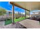 Covered patio with artificial turf and seating area at 7745 Rosebark Cliffs St, North Las Vegas, NV 89084