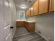 Laundry room with wooden cabinets, vinyl flooring, and a window at 8505 Spotted Fawn Ct, Las Vegas, NV 89131