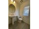 Small bathroom with pedestal sink, toilet, and window at 11751 Emerald Lake Ave, Las Vegas, NV 89138