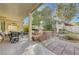 Covered patio, seating area, and landscaped backyard with trees at 1259 Moon Vision St, Henderson, NV 89052