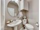 Small bathroom with pedestal sink, toilet, and round mirror at 1556 Bryce Canyon St, Boulder City, NV 89005