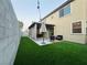 View of backyard with artificial grass, seating and covered patio at 1908 W Hammer Ln, North Las Vegas, NV 89031