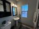 Clean bathroom with pedestal sink, window, and updated vanity at 1908 W Hammer Ln, North Las Vegas, NV 89031