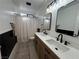 Updated bathroom with dual sink vanity and black framed mirrors at 1908 W Hammer Ln, North Las Vegas, NV 89031