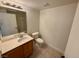 Bathroom with vanity, toilet, mirror, lighting and a shower behind the mirror, all on a tile floor at 2001 Jasper Bluff St # 102, Las Vegas, NV 89117