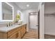 Bright bathroom featuring double sinks, a walk-in closet, and stylish light fixtures at 2500 W Oakey Blvd, Las Vegas, NV 89102