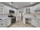 Modern white kitchen with stainless steel appliances and an eat-in island at 2856 Billy Casper Dr, Las Vegas, NV 89134