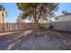 View of a simple backyard with a tree and a wooden fence at 332 Oakford St, Las Vegas, NV 89110