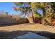 Backyard with a large tree, wooden fence, and a concrete slab at 332 Oakford St, Las Vegas, NV 89110