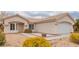 Tan house with a two-car garage and nicely landscaped front yard at 3606 Altar Rock Ln, North Las Vegas, NV 89032