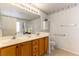 Double vanity bathroom with wood cabinets and tiled floors at 3728 Discovery Creek Ave, North Las Vegas, NV 89031