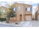 Two-story house with beige exterior, attached garage, and landscaping at 4129 Chamisa Cove St, Las Vegas, NV 89115