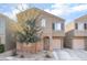 Beige two-story house with attached garage and a tree in front at 4129 Chamisa Cove St, Las Vegas, NV 89115