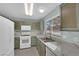 White appliances and light green cabinets in this galley style kitchen at 429 Nancy Dr, Henderson, NV 89015