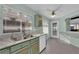 Bright kitchen with light green cabinets, stainless steel sink, and white appliances at 429 Nancy Dr, Henderson, NV 89015