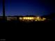 Night view of a ranch-style home with lit landscaping and a large backyard at 4351 W Bell Vista Ave, Pahrump, NV 89060