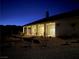 Night view of a home with a covered patio and walkway leading to the yard at 4351 W Bell Vista Ave, Pahrump, NV 89060