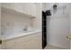 Bright laundry room featuring white cabinetry, sink, and storage shelves for efficient organization at 4532 Laguna Vista St, Las Vegas, NV 89147