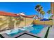 Backyard pool and spa with a clear blue water under a bright sky, surrounded by palm trees and a yellow privacy wall at 4532 Laguna Vista St, Las Vegas, NV 89147