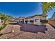 Expansive backyard with desert landscaping, mature trees, and a tranquil birdbath at 5170 Agio Ave, Pahrump, NV 89061