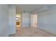 Bright, airy bedroom with neutral walls and carpet, showcasing access to the bathroom and hallway at 5340 Silvermist Ct # 103, Las Vegas, NV 89122