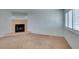 Cozy living room with a tiled fireplace, neutral carpet, and bright natural light from shuttered windows at 5340 Silvermist Ct # 103, Las Vegas, NV 89122