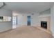 Spacious living room with a fireplace, carpet flooring, and an open view into the adjacent kitchen and dining area at 5340 Silvermist Ct # 103, Las Vegas, NV 89122