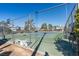 Community tennis court surrounded by fencing, trees, and blue sky at 5340 Silvermist Ct # 103, Las Vegas, NV 89122