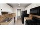 Kitchen with white cabinets, black appliances, and tile floor at 5453 Requa Ave, Las Vegas, NV 89110