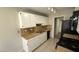 Kitchen with white cabinets, black appliances and tile floors at 5453 Requa Ave, Las Vegas, NV 89110