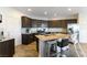 Modern kitchen with dark cabinets, granite island and stainless steel appliances at 5824 Petrified Tree Ln, North Las Vegas, NV 89081