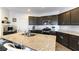 Modern kitchen with dark cabinets, granite island and stainless steel appliances at 5824 Petrified Tree Ln, North Las Vegas, NV 89081