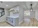 Modern kitchen featuring gray cabinets, quartz countertops, and floating shelves at 647 Greenbriar Townhouse Way, Las Vegas, NV 89121