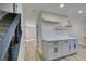 Kitchen with gray cabinets, floating shelves, and quartz countertops at 647 Greenbriar Townhouse Way, Las Vegas, NV 89121