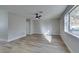 Living room featuring light walls, wood-look floors, and a ceiling fan at 647 Greenbriar Townhouse Way, Las Vegas, NV 89121