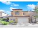 Two-story house with beige exterior, shutters, and a two-car garage at 7490 Thistle Poppy St, Las Vegas, NV 89139