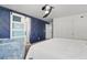 Spacious bedroom with stylish barn door and blue accent wall at 7638 Peaceful Trellis Dr, Las Vegas, NV 89179