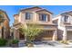 Beige two-story house with a brown garage door at 7638 Peaceful Trellis Dr, Las Vegas, NV 89179