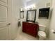 Well-lit bathroom with a cherry-wood vanity, black countertop, and a wall-mounted cabinet at 833 Aspen Peak Loop # 1014, Henderson, NV 89011