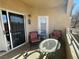 Neutral patio with sliding door, two chairs with striped cushions, and glass-topped tables at 833 Aspen Peak Loop # 1014, Henderson, NV 89011