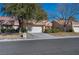 Tan two-story home with a red tile roof, attached garage, and landscaped front yard at 8608 Millsboro Dr, Las Vegas, NV 89134