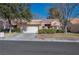 Tan two-story home with a red tile roof, attached garage, and landscaped front yard at 8608 Millsboro Dr, Las Vegas, NV 89134